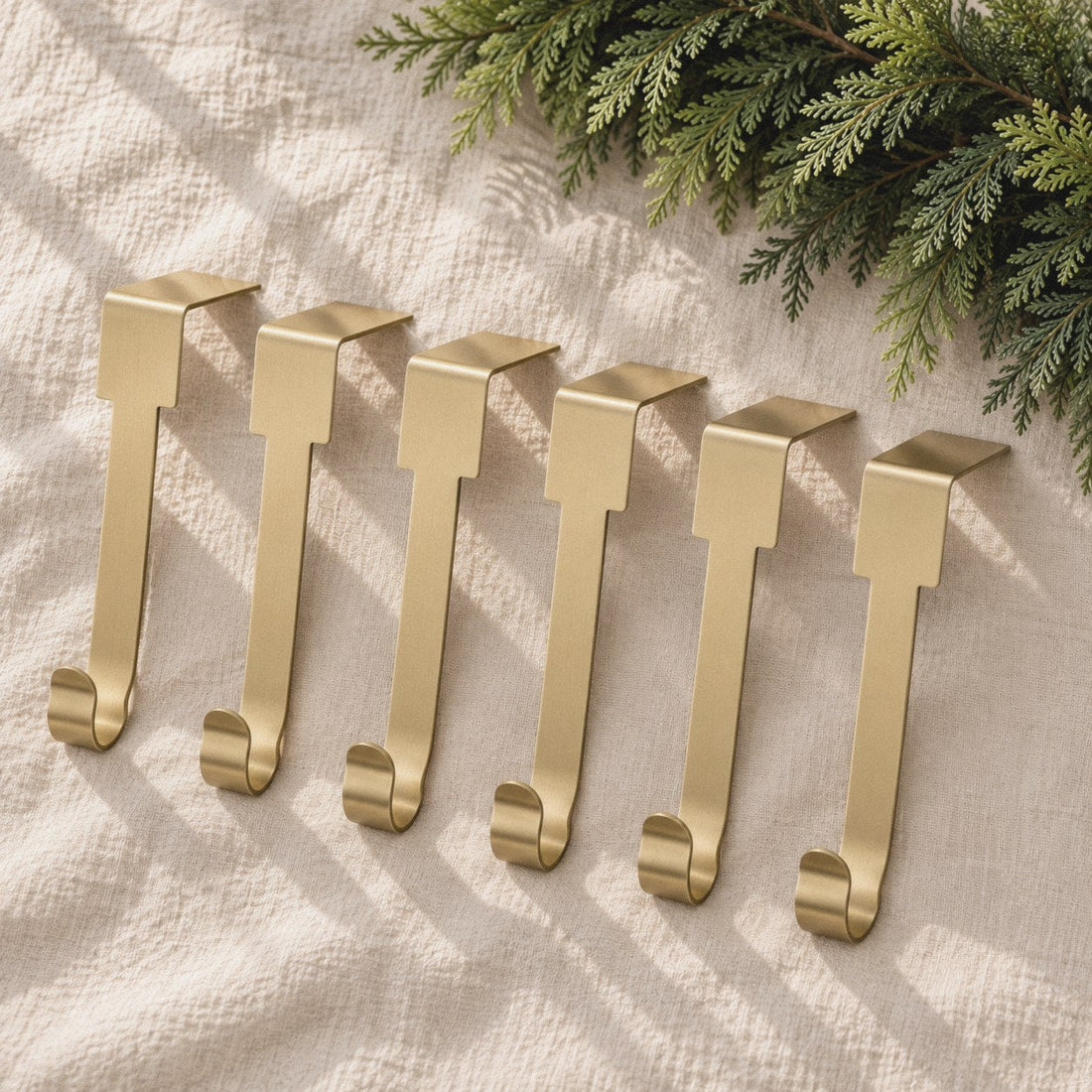 Six gold mantel hooks on cream linen