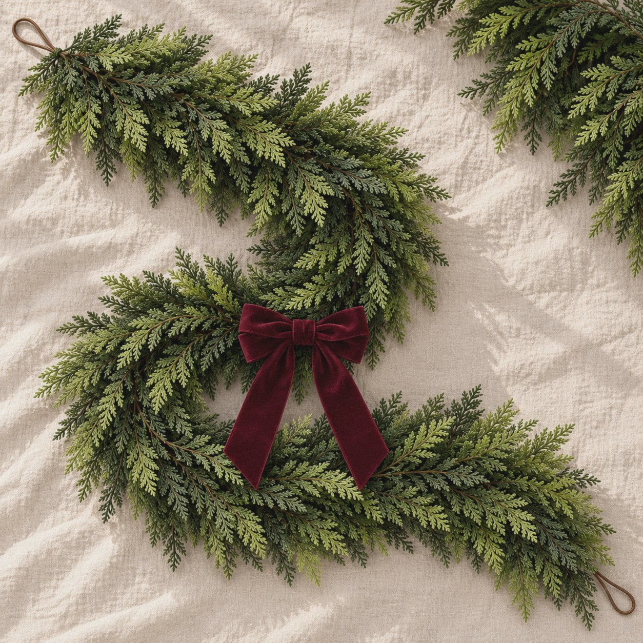 The Holiday Cedar Garland: faux cedar garland with a velvet bow on linen